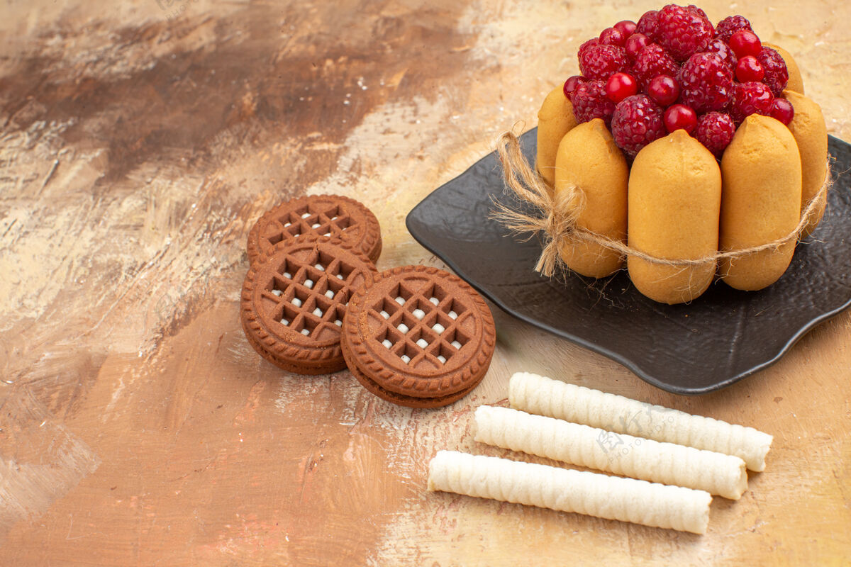 盘子一个礼物蛋糕和饼干在棕色的盘子水果上混合颜色的桌面视图新鲜健康覆盆子