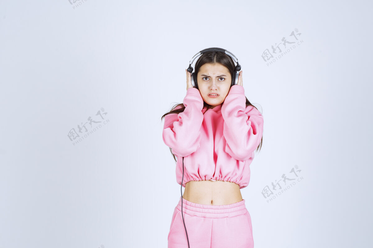 娱乐穿着粉色睡衣的女孩在听耳机 不喜欢音乐人年轻服装