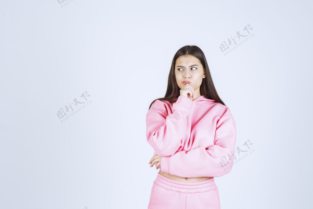 人穿粉红色睡衣的女孩看起来既困惑又体贴没有经验工人员工