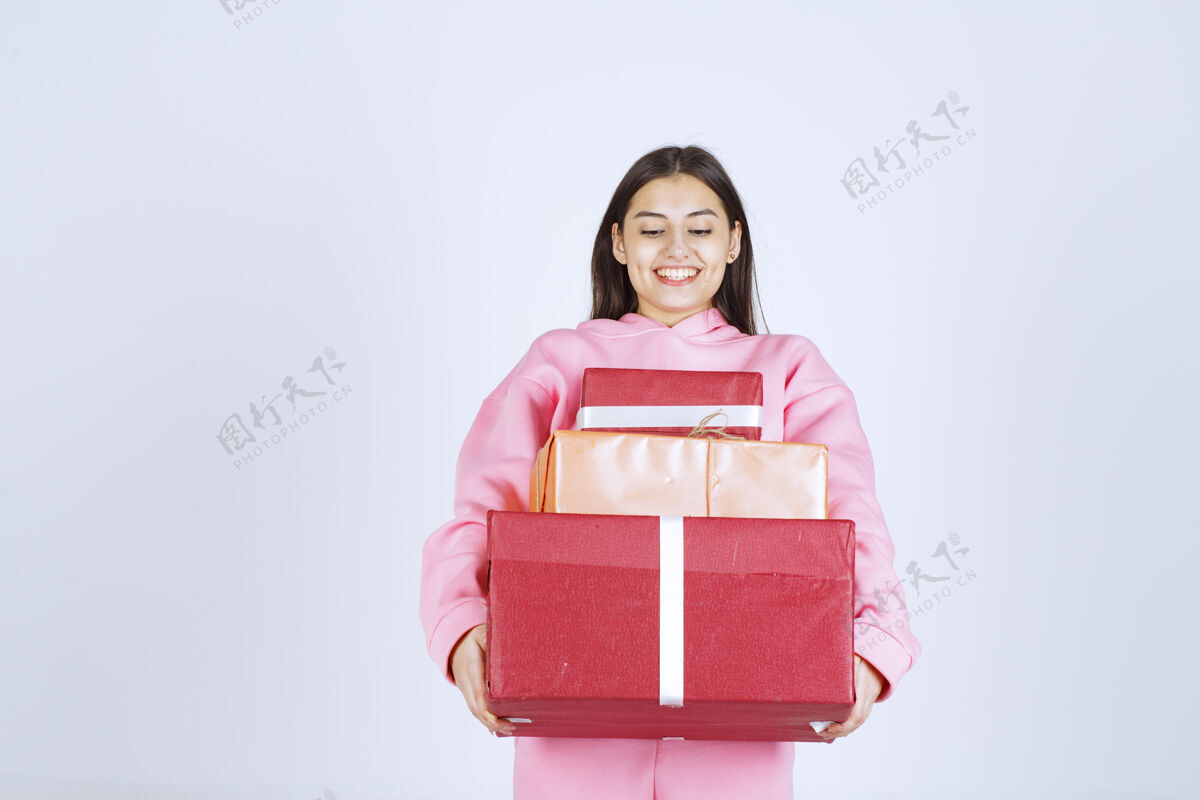 乐趣穿着粉色睡衣的女孩手里拿着多个红色礼盒 心情很开心聪明女人工人