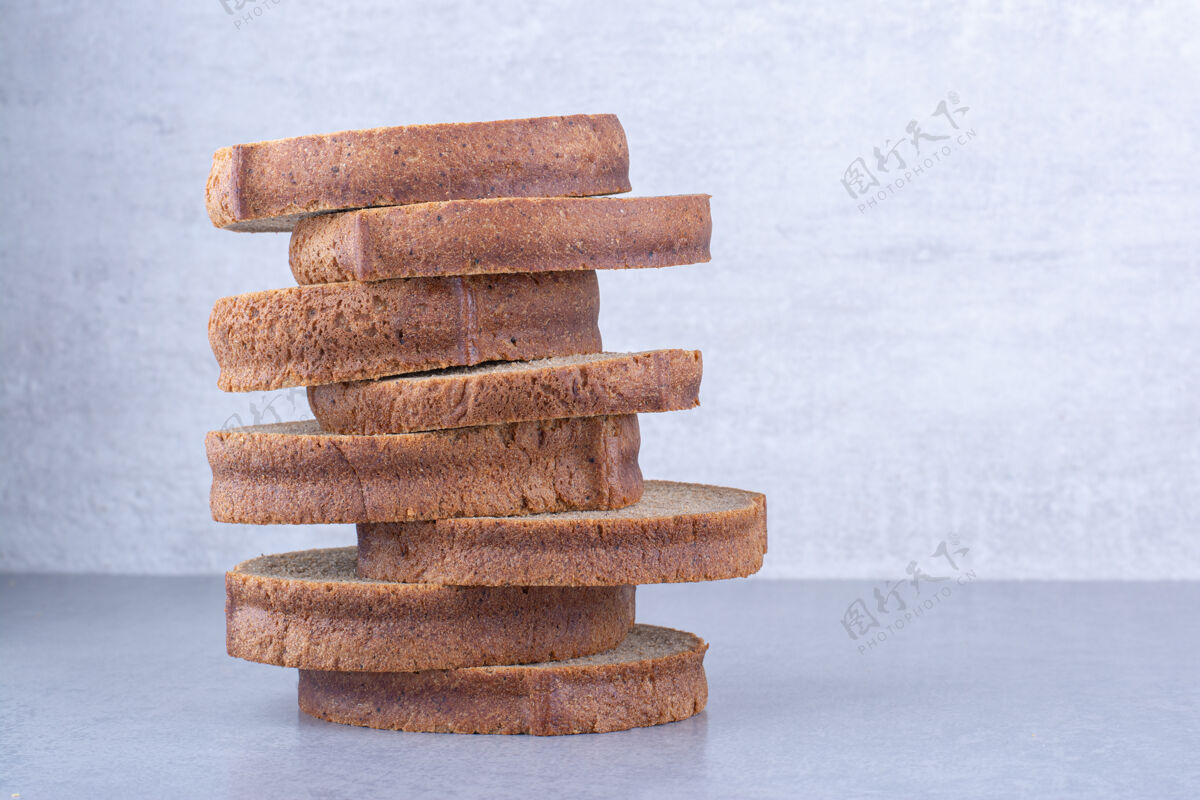 面包棕色的面包片堆在大理石表面面包片饮食营养