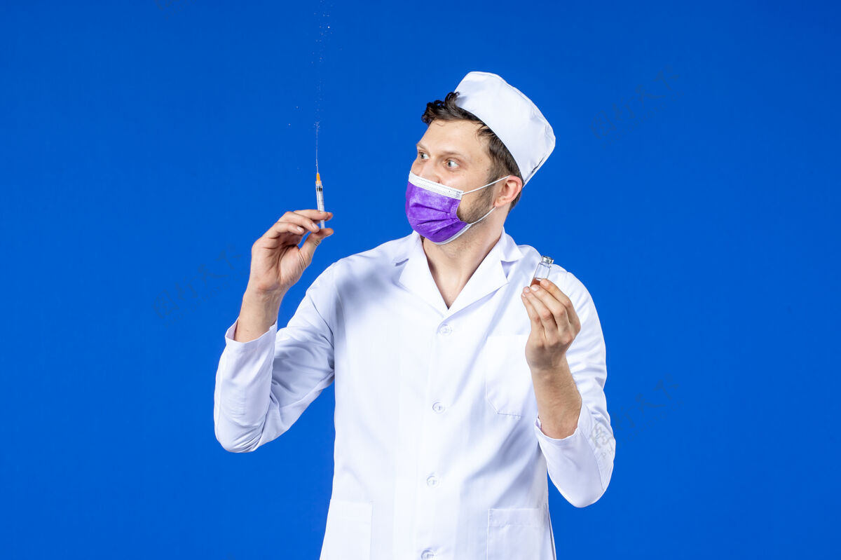 医院男医生的前视图 穿着医疗服 戴着蓝色的疫苗注射面罩填充物套装男医生