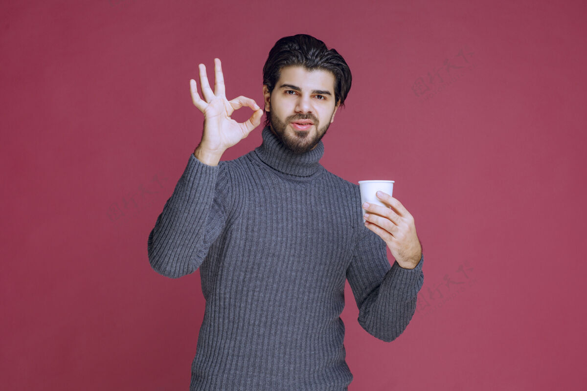 拇指男人拿着一个一次性咖啡杯 做着享受的手势语言人交易