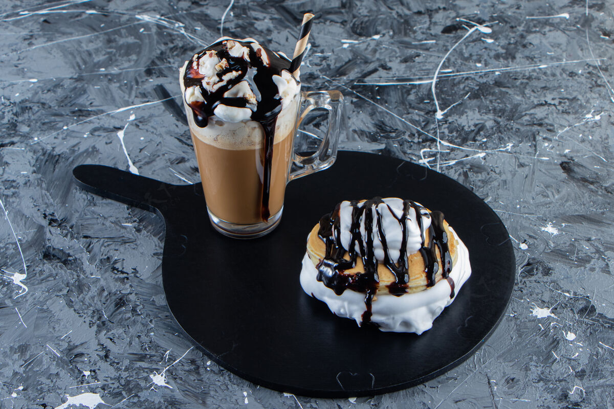 泡沫在木板上放上巧克力馅饼和一杯咖啡鲜奶油自制沙司