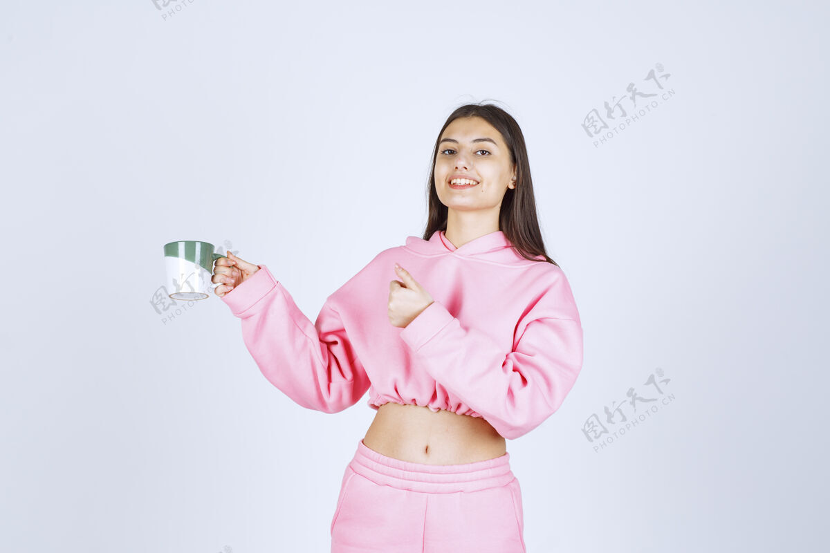 工人穿着粉色睡衣的女孩拿着咖啡杯 享受着咖啡的味道年轻人人体模特休闲