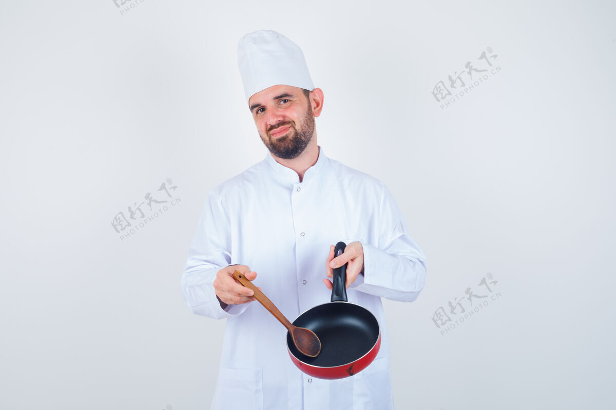 过度工作身穿白色制服的年轻男厨师展示着空煎锅和木勺 看上去很失望 正面图失败男性沮丧