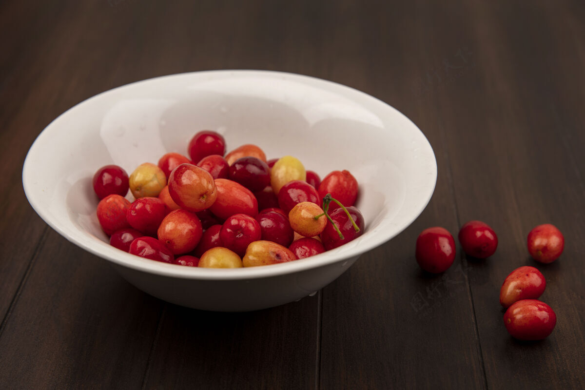 食物木制表面上的白色碗上的红色茱萸樱桃俯视图饮食美味营养