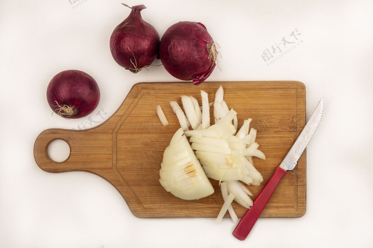 薯条顶视图新鲜的白色洋葱在一个木制的菜板与刀与红洋葱隔离在一个白色的表面板木材膳食