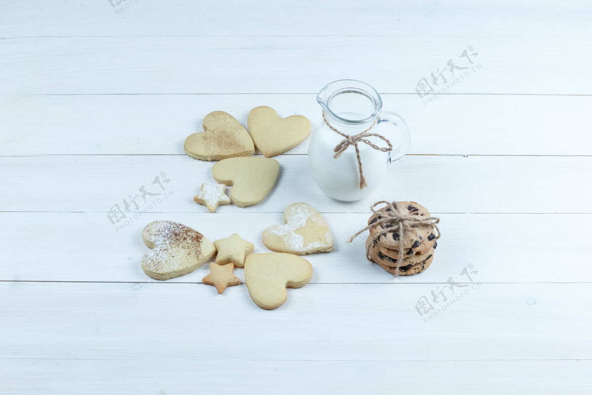 星星高角度观看心形和星形饼干 白色木板背景上有一罐牛奶水平板脆角度