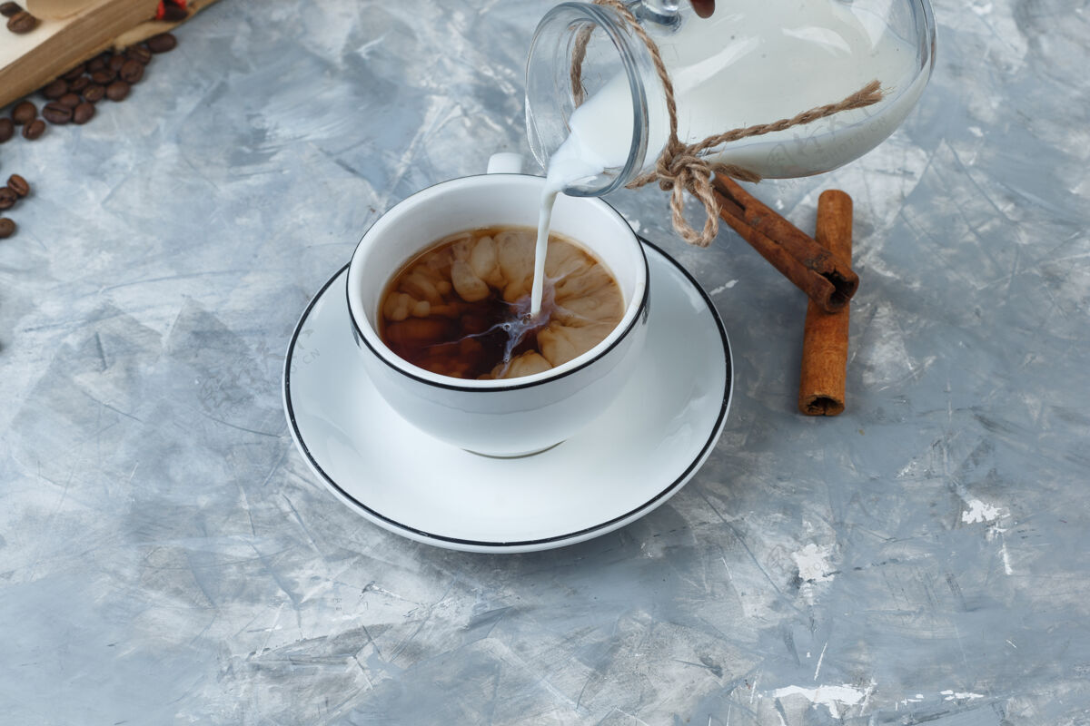 咖啡因高角度观看倒入牛奶的咖啡杯 咖啡豆 肉桂棒的灰色背景水平早餐卡布奇诺意式浓缩咖啡
