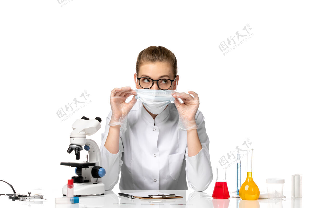 正面前视图：女医生穿着医疗服 带无菌口罩 因为在浅白色空间上有covid大流行疾病面具