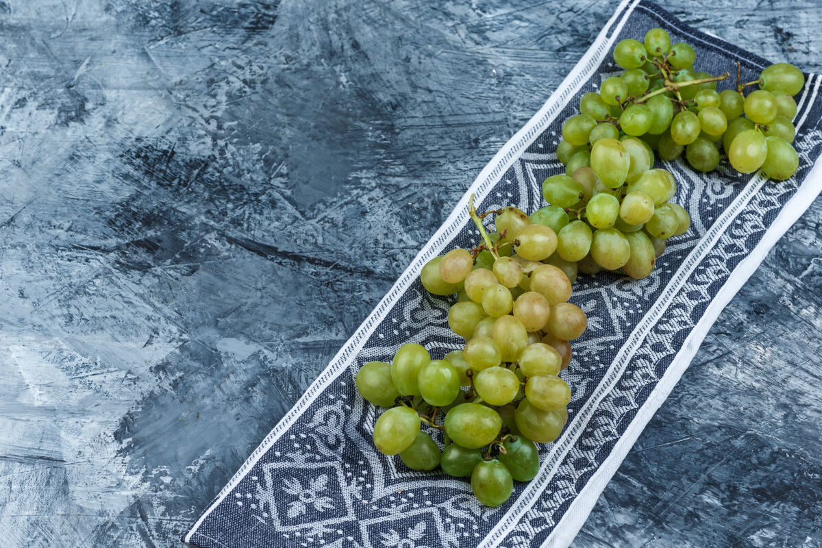角新鲜葡萄在垃圾和厨房毛巾背景上的高角度视图葡萄藤分支酒庄