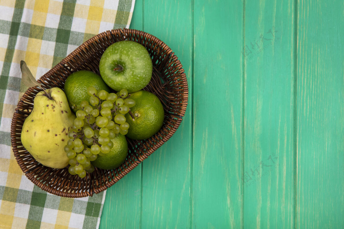 景观顶视图复制空间绿色的葡萄与绿色的苹果 橘子和梨在一个绿色的墙上篮子篮子苹果顶部