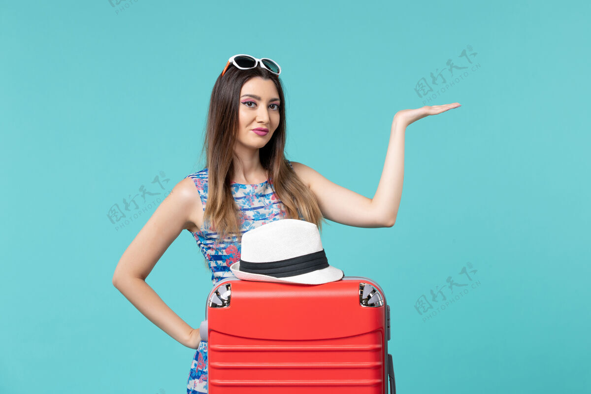 前面前视图美丽的女性准备度假与红色的袋子和帽子在浅蓝色的空间漂亮性感准备