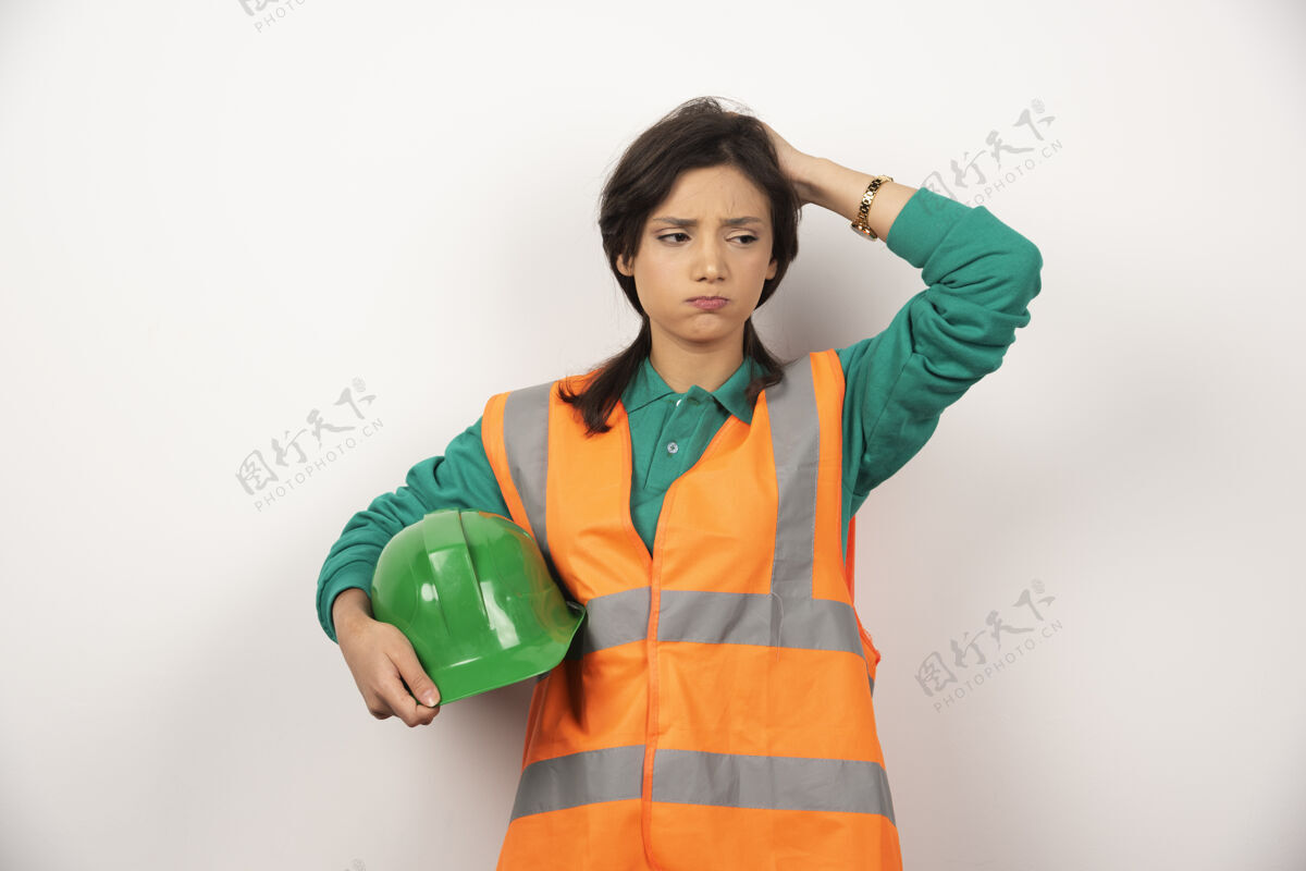 建筑工人心烦意乱的女工程师抓着头 拿着白色背景的头盔女性女士人