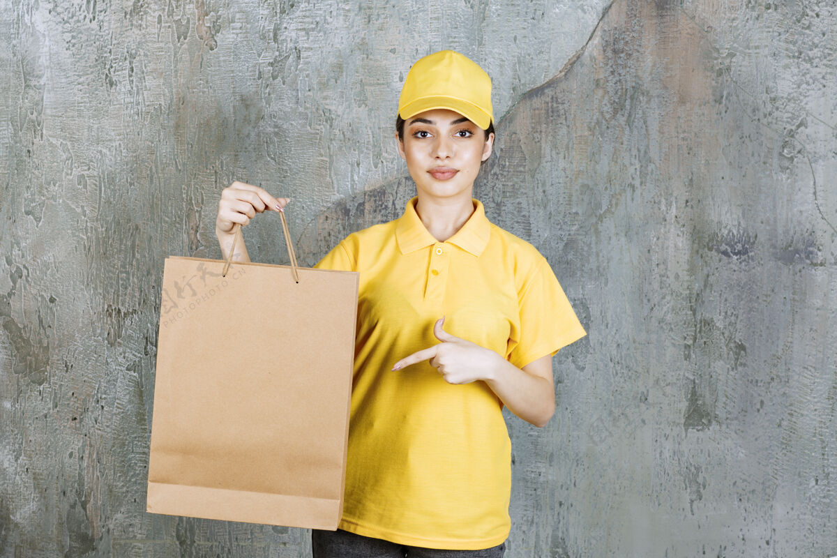 送货穿着黄色制服的女服务人员拿着购物袋员工快递工人