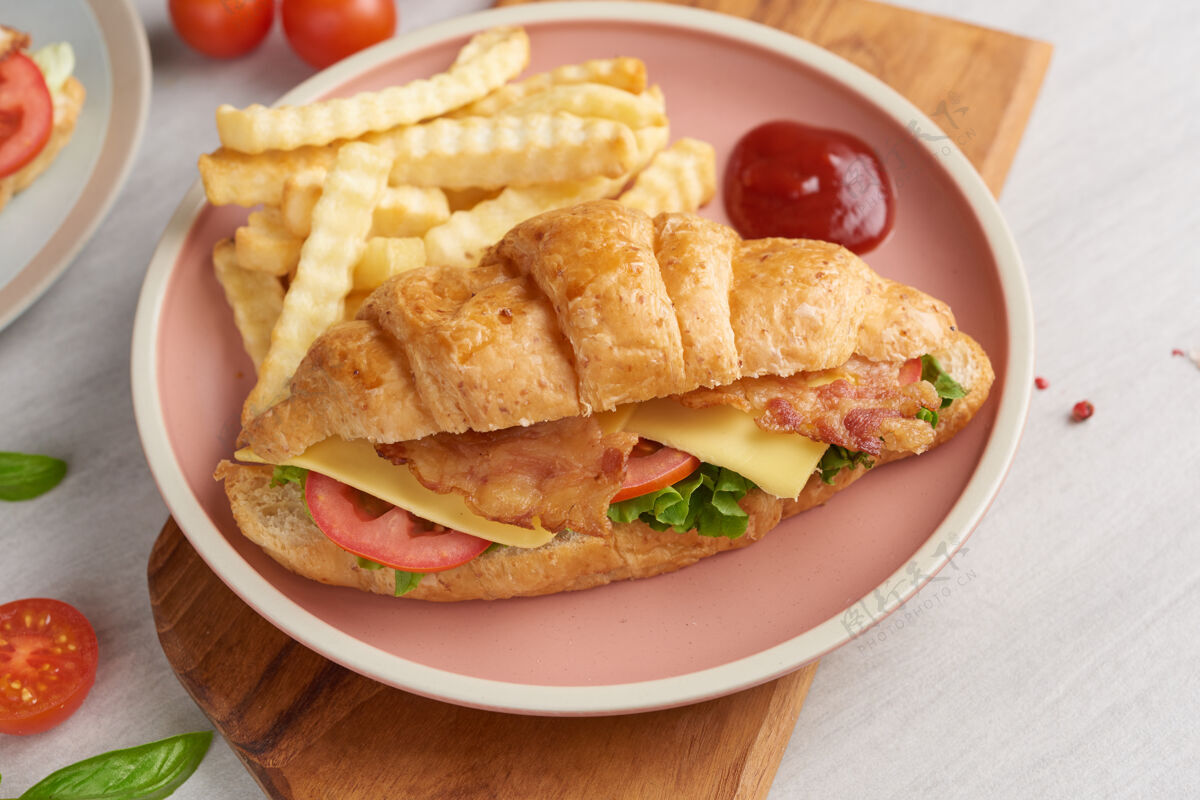 糕点两个羊角面包三明治放在木桌上 顶视图 英语薯条番茄