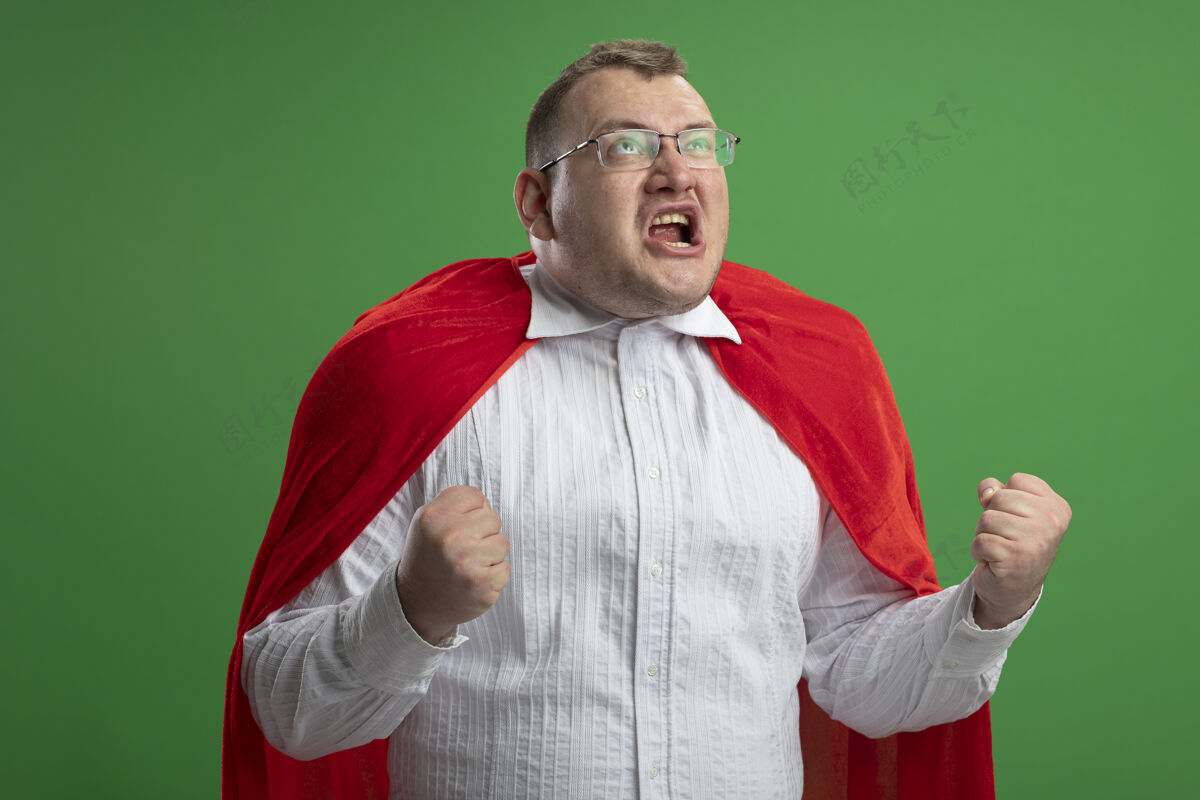 斯拉夫快乐的成年斯拉夫超级英雄 穿着红斗篷 戴着眼镜 在绿墙上做着“是”的手势斗篷穿着男人