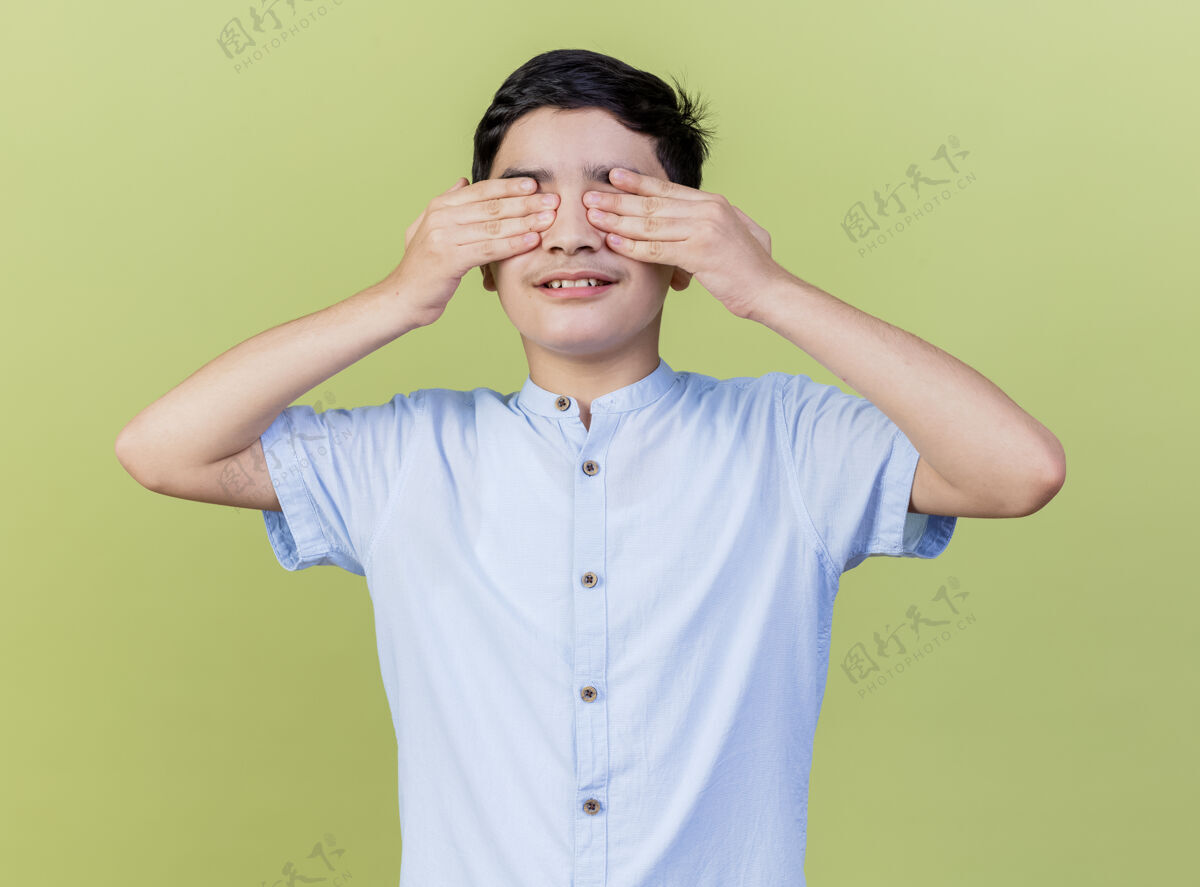 孩子年轻的白人男孩用手遮住眼睛 隔离在橄榄绿的墙上掩护奥利弗年轻