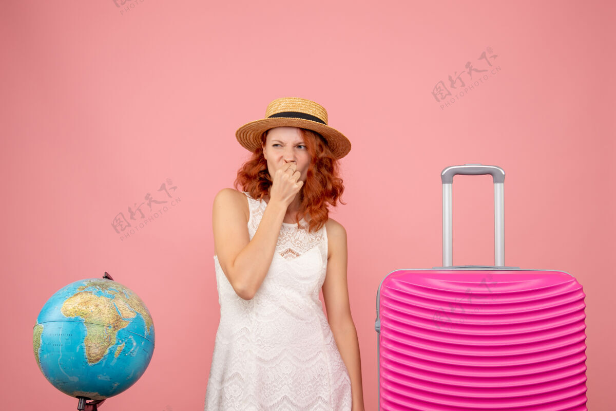 度假年轻女性游客的正面图 粉红色的墙上挂着粉红色的包服饰旅行人