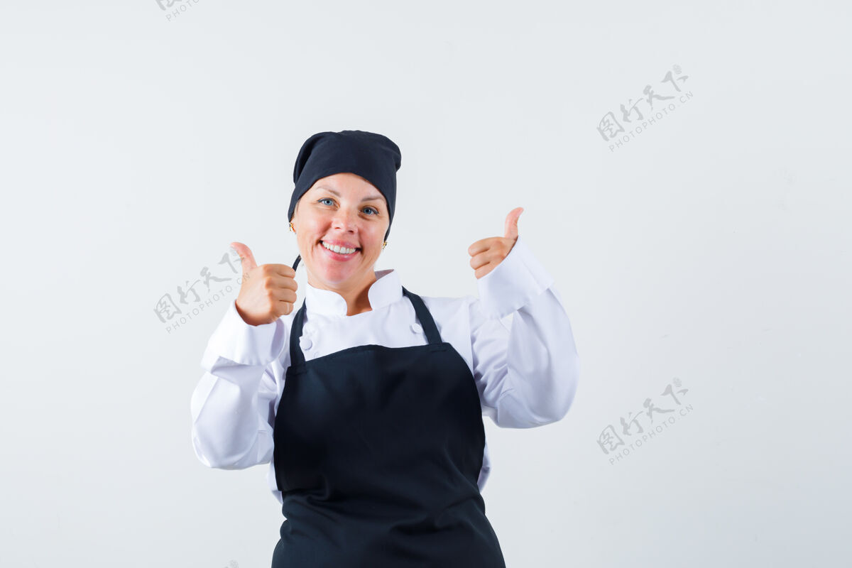可爱女厨师穿着制服 围裙 双手竖起大拇指 看上去很快乐 正面视图漂亮成人女人
