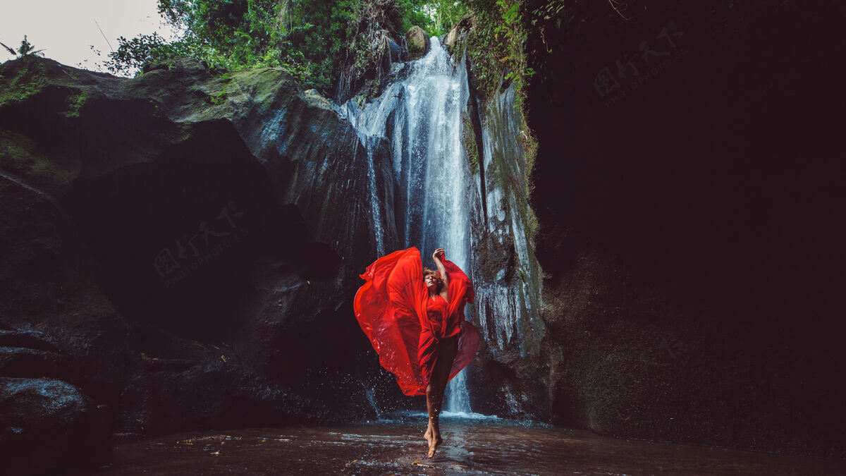 瀑布穿红裙子的女孩在瀑布里跳舞情感动作舞蹈