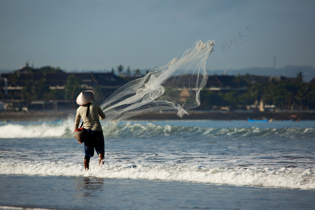 日落一个人在用网钓鱼海工作水