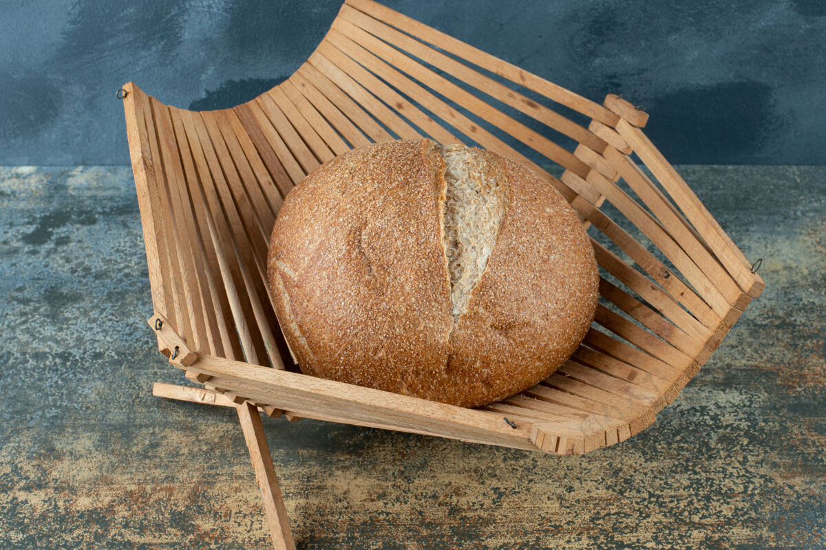 棕色一个新鲜的棕色面包包放在木篮子里圆形健康自然