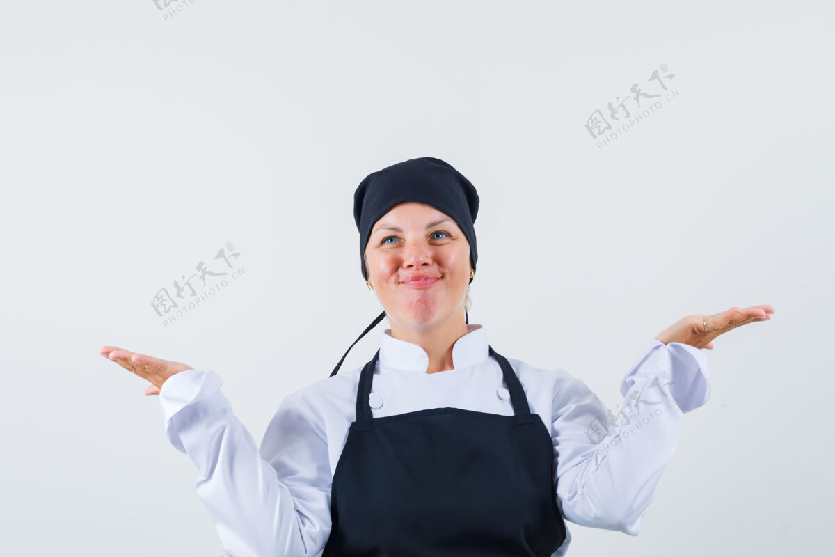漂亮女厨师身着制服 围裙 神采奕奕地做着秤的手势正面图成人制服欢呼