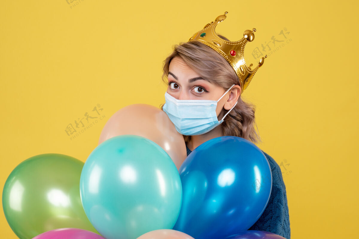 聚会年轻的女性拿着黄色的无菌面具气球乐趣观点气球
