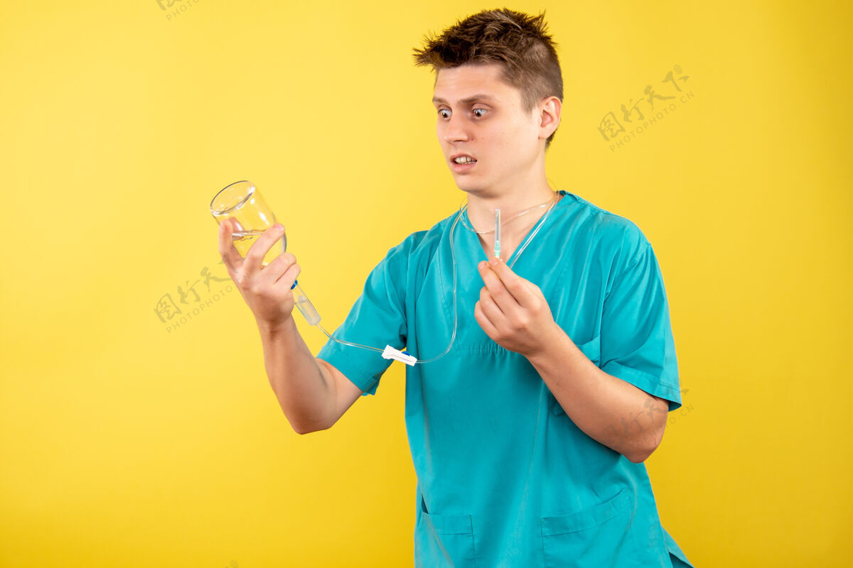 高尔夫球手正面图身穿医疗服的年轻男医生拿着黄色背景上的滴管球员人西装