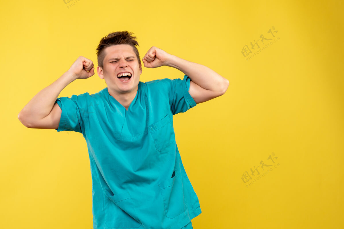 医学正面图身着医疗服的年轻男医生在黄色背景上喜气洋洋男性人医学