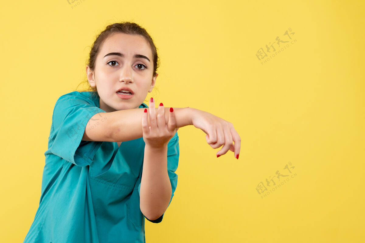 手正面图年轻女医生穿着医疗服 手受伤 背景为黄色健康伤害肖像