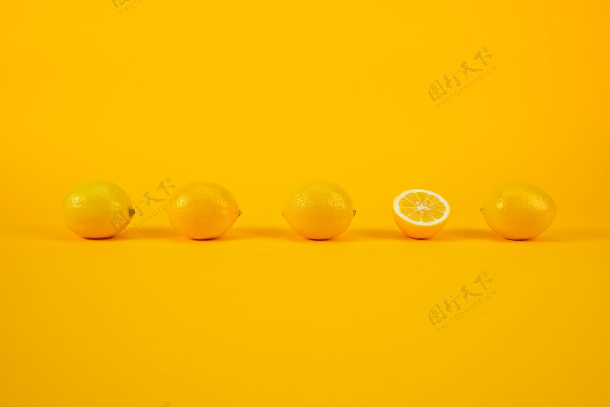 半黄色墙上的柠檬新鲜生的多汁