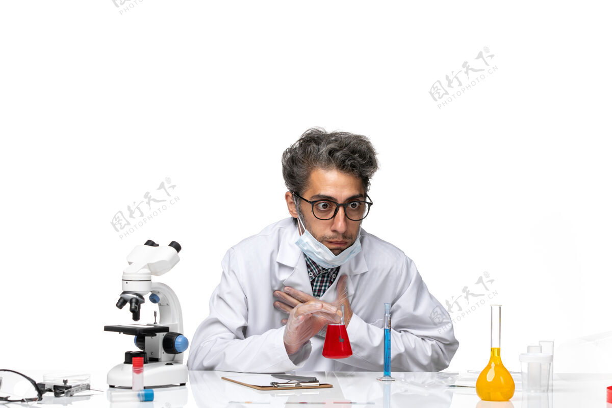 前面正面图中年科学家穿着特制的白西装闻着红色的溶液医学科学男人