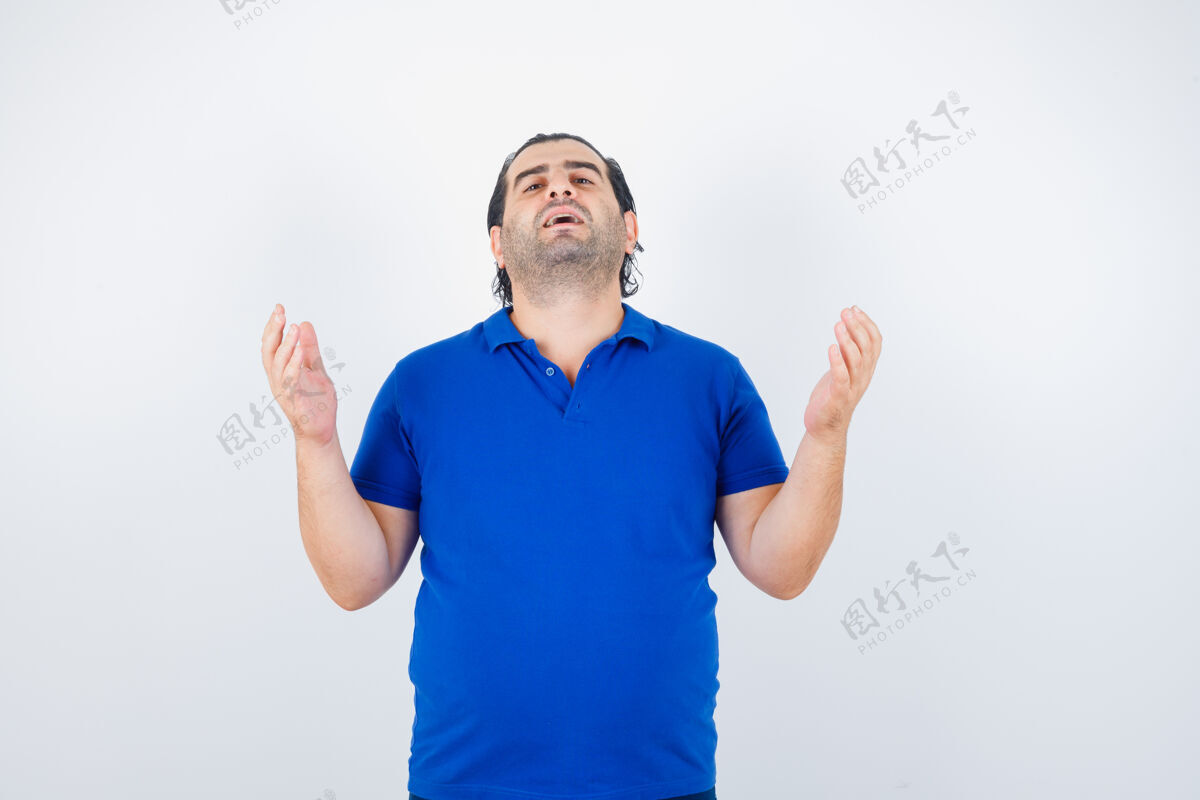 人身穿蓝色t恤的中年男子举手祈祷 看上去充满希望 正面照思想祈祷胡须