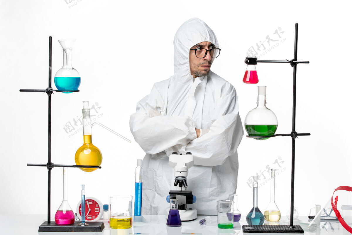 视图正面图穿着特殊防护服的男科学家站在桌子周围 拿着解决方案研究医疗实验室