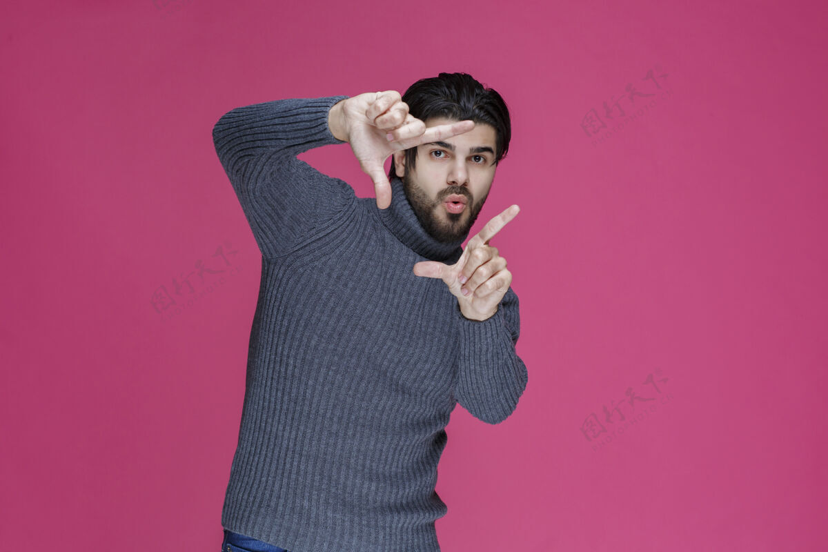 摄影师一个穿灰色毛衣的男人正在做相框的手势模特休闲聪明