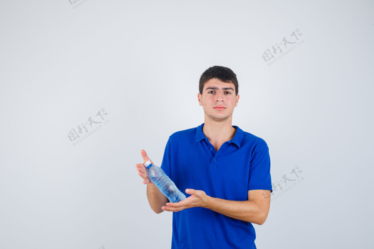 人类一个穿着t恤的年轻人手里拿着塑料瓶 看上去很自信 前视图瓶子乐趣快乐
