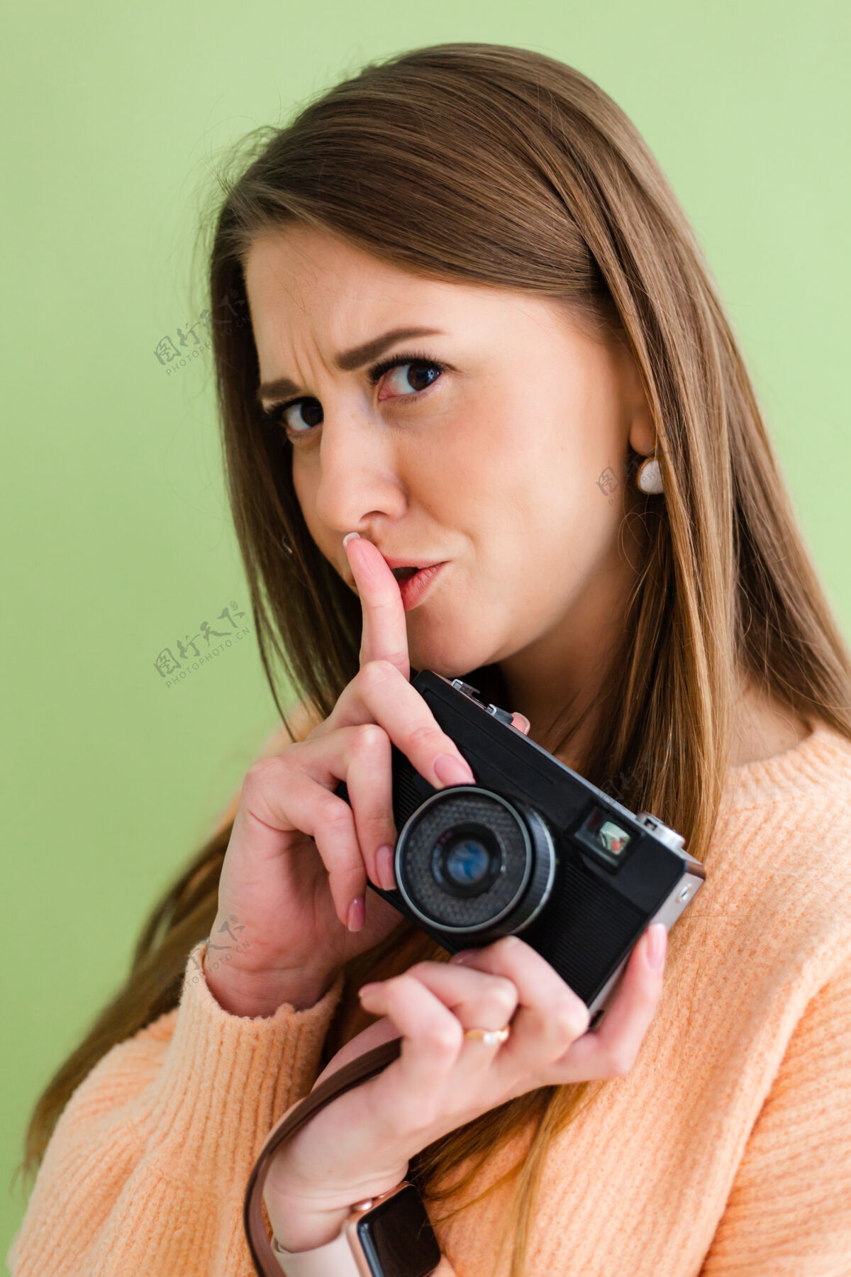微笑漂亮的欧洲女人手里拿着相机 用手指表示嘘 沉默的手势摄影相机摄影师游客