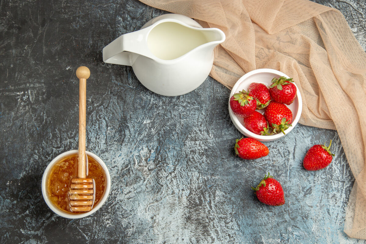 蜂蜜顶视图新鲜的红色草莓与蜂蜜在黑暗的光表面红色水果浆果水果碗容器
