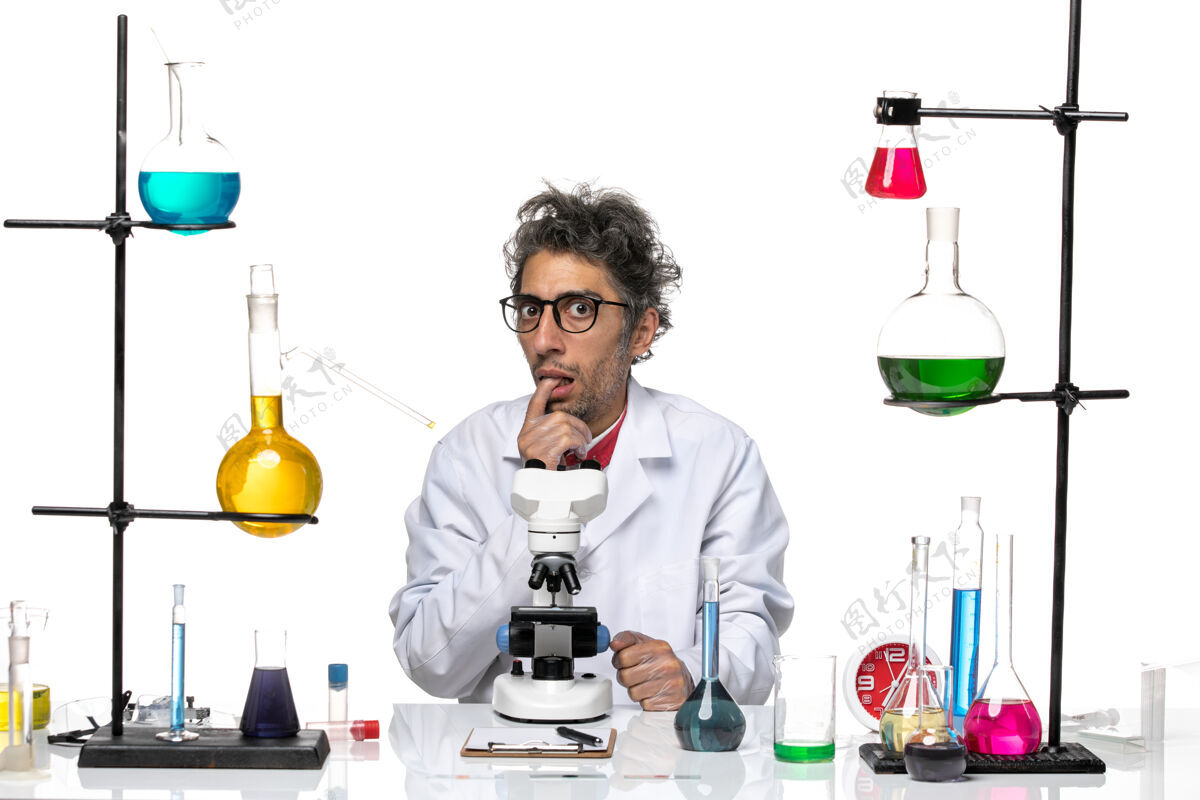 玻璃正面图穿着白色医疗服的男科学家在做鬼脸化学实验室科学