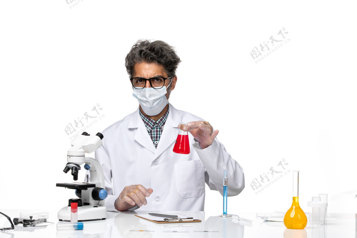 红色正面图穿着特殊套装的中年科学家坐着拿着装有红色溶液的烧瓶专业实验室外套研究