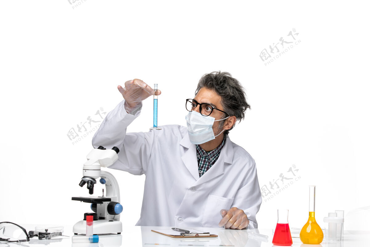 科学正面图中年科学家穿着特制的衣服坐着拿着装有溶液的烧瓶实验室人实验室
