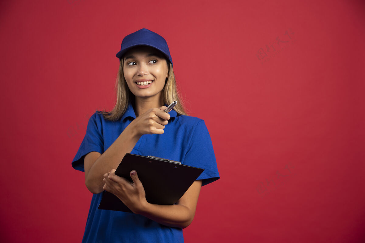 人类身着蓝色制服的微笑女子拿着剪贴板和铅笔摆姿势女孩人女性