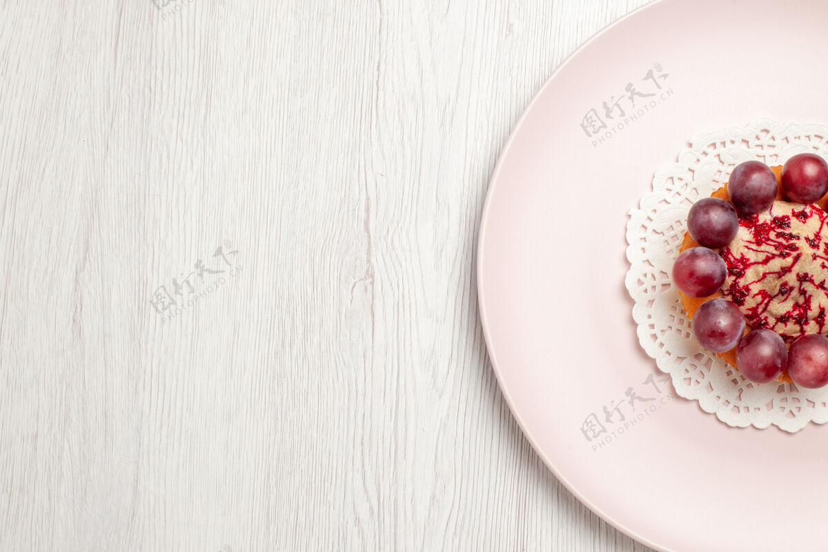 早餐顶视图小蛋糕与葡萄内板上的白色地板水果甜点蛋糕食物健康餐