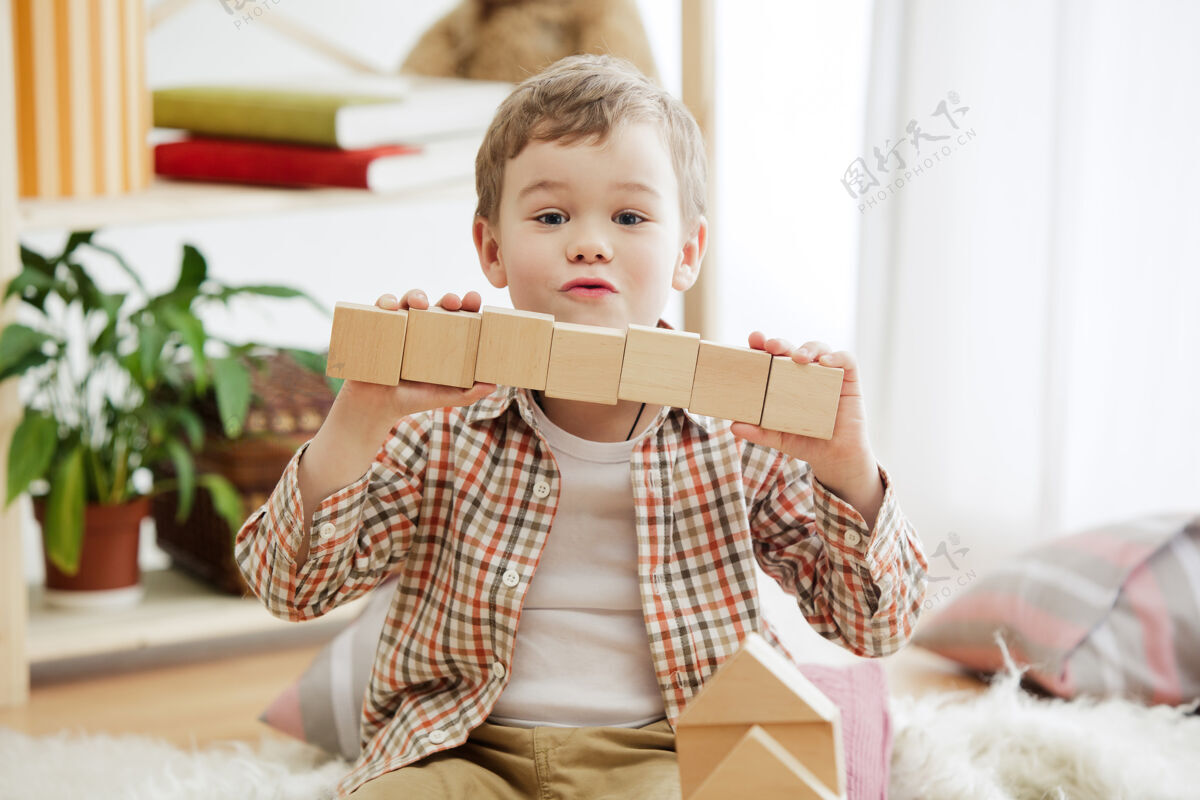 游戏小孩子坐在地板上漂亮的男孩在家里玩木块幼儿园室内活动