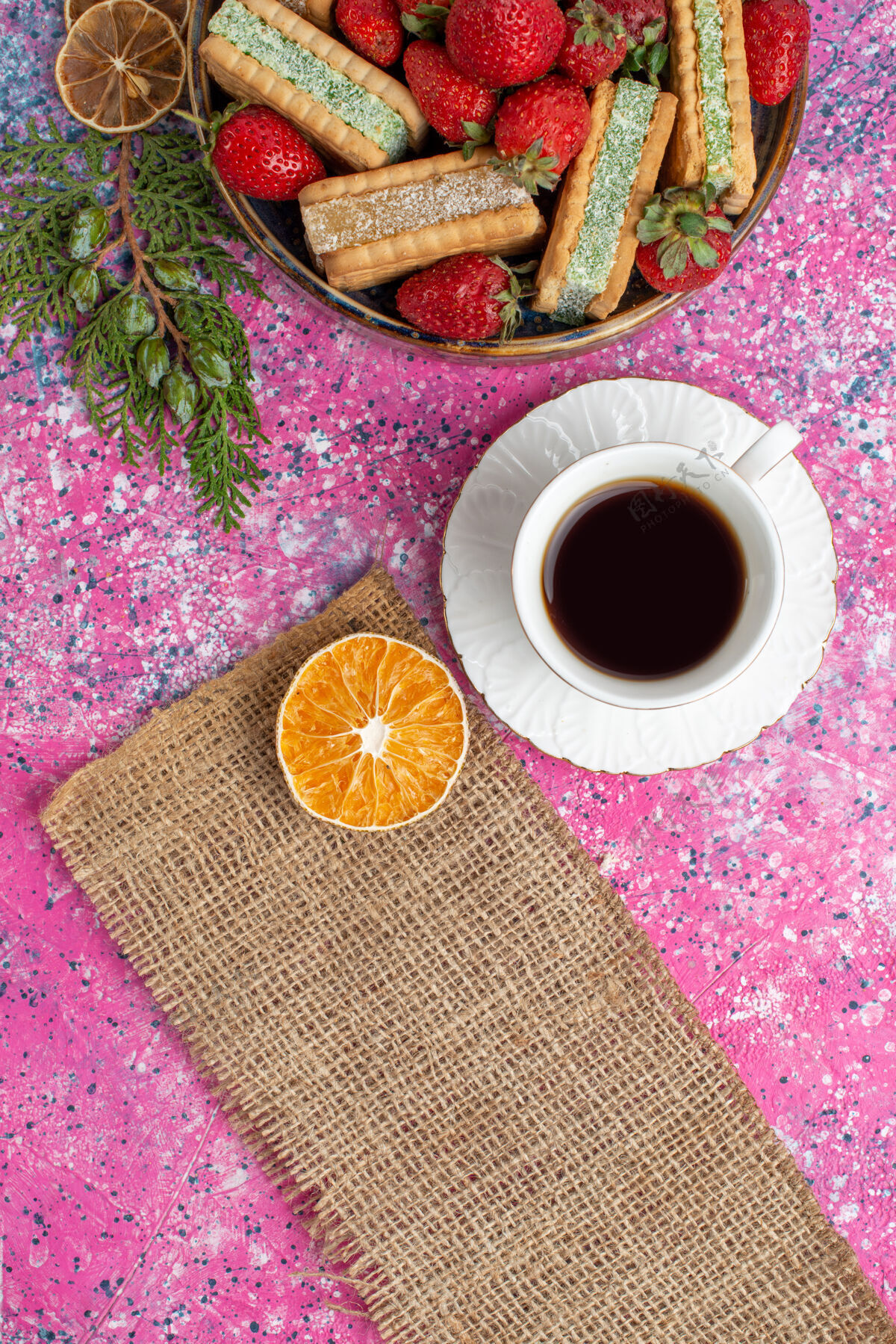 茶俯瞰美味的华夫饼干 新鲜的红色草莓和一杯茶在粉红色的表面美味的杯子华夫饼