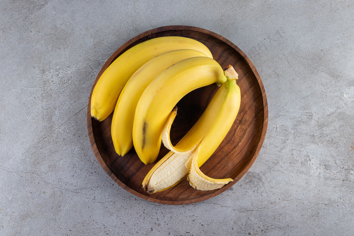 果皮一堆多汁的黄色香蕉放在石桌上营养蔬菜成熟