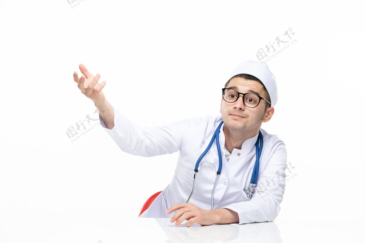 疾病正面图：男医生穿着医疗服坐在桌子后面听诊器坐姿医院